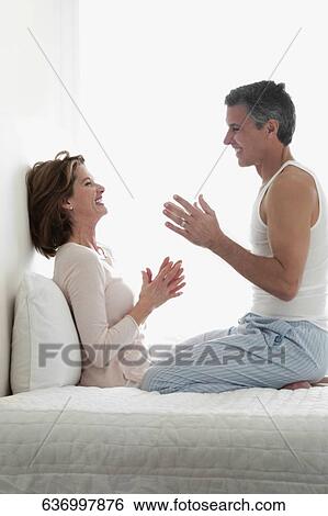 Couple romancing in the bedroom View Large Photo Image Stock Photograph - Couple romancing in the bedroom. Fotosearch