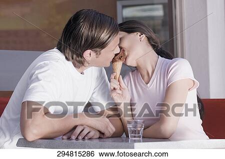 Couple sharing ice cream in an ice cream parlor View Large Photo Image Stock Photograph - Couple sharing ice cream in an ice cream parlor. Fotosearch
