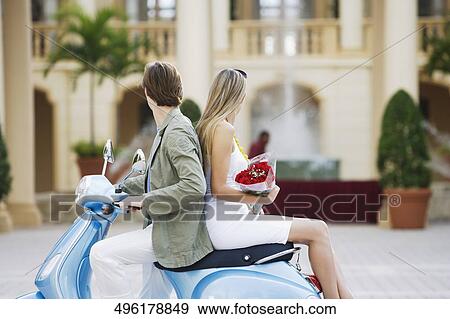 Couple sitting on a moped, Biltmore Hotel, Coral Gables, Florida, USA View Large Photo Image Stock Photo - Couple sitting on a moped, Biltmore Hotel, Coral Gables, Florida, USA. Fotosearch