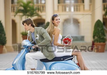 Couple sitting on a moped, Biltmore Hotel, Coral Gables, Florida, USA View Large Photo Image Stock Photo - Couple sitting on a moped, Biltmore Hotel, Coral Gables, Florida, USA. Fotosearch