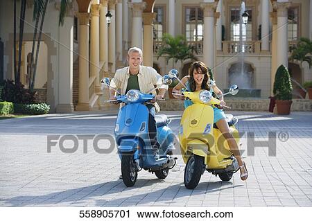 Couple sitting on mopeds, Biltmore Hotel, Coral Gables, Florida, USA View Large Photo Image Stock Image - Couple sitting on mopeds, Biltmore Hotel, Coral Gables, Florida, USA. Fotosearch