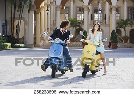 Couple sitting on mopeds, Biltmore Hotel, Coral Gables, Florida, USA View Large Photo Image Stock Photograph - Couple sitting on mopeds, Biltmore Hotel, Coral Gables, Florida, USA. Fotosearch