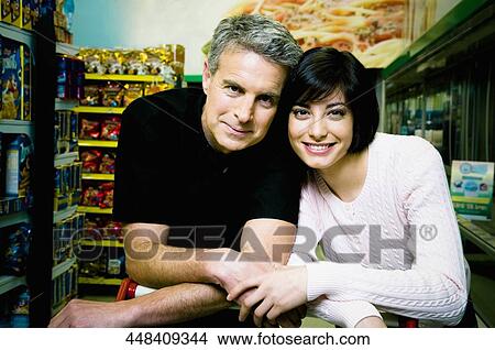 Couple smiling in a supermarket View Large Photo Image Picture - Couple smiling in a supermarket. Fotosearch