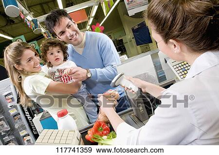 Couple standing at the checkout counter in a supermarket View Large Photo Image Stock Photo - Couple standing at the checkout counter in a supermarket. Fotosearch
