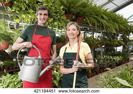 Couple standing in a greenhouse View Large Photo Image Stock Image - Couple standing in a greenhouse. Fotosearch
