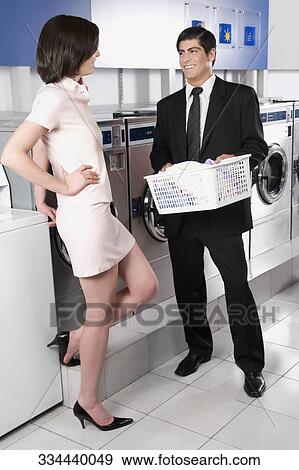 Stock Photo - Couple talking to each other in a laundromat. Fotosearch