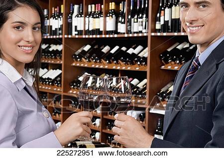 Couple toasting with wine glasses in a bar View Large Photo Image Stock Image - Couple toasting with wine glasses in a bar. Fotosearch