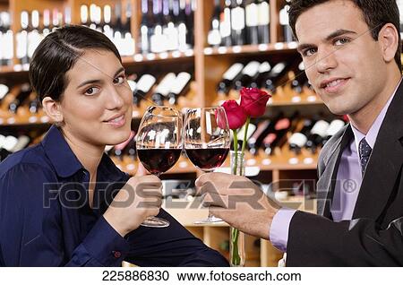 Couple toasting with wine in a bar View Large Photo Image Stock Image - Couple toasting with wine in a bar. Fotosearch