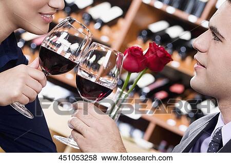 Stock Photo - Couple toasting with wine in a bar. Fotosearch