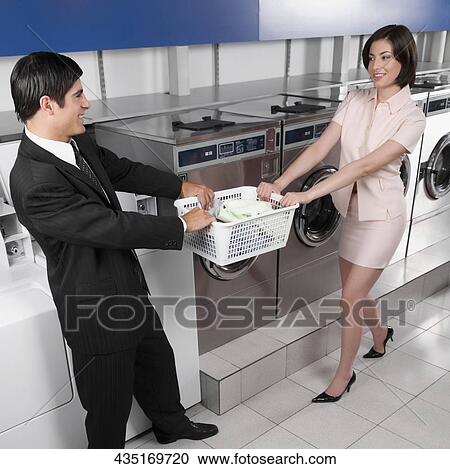 Couple tugging a basket in a laundromat View Large Photo Image Stock Image - Couple tugging a basket in a laundromat. Fotosearch