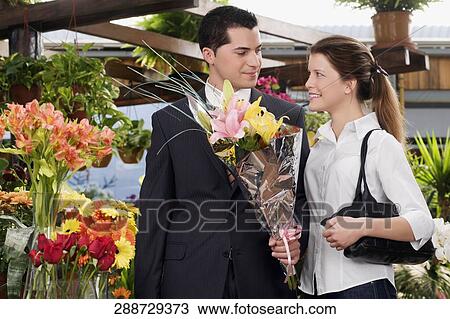 Couple with a bouquet of flowers in a florist shop View Large Photo Image Stock Image - Couple with a bouquet of flowers in a florist shop. Fotosearch