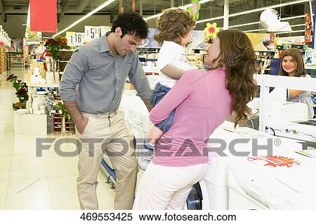 Stock Photography - Couple with their children in a supermarket. Fotosearch