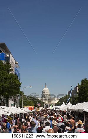 Stock Image - Crowd in a gay pride parade with a government building in the background, State Capitol Building, Washington DC, USA. Fotosearch