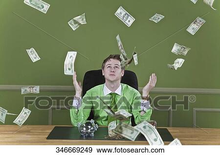 Currency notes falling over a businessman View Large Photo Image Stock Photo - Currency notes falling over a businessman. Fotosearch