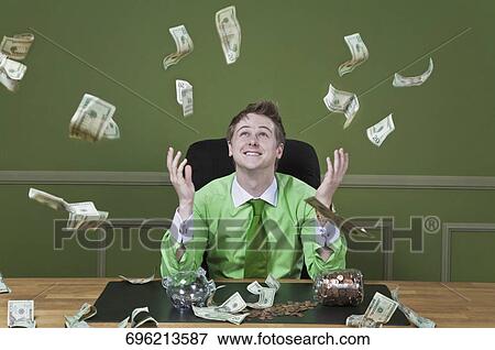 Currency notes falling over a businessman View Large Photo Image Stock Photo - Currency notes falling over a businessman. Fotosearch