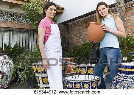 Stock Image - Customer buying decorative urns. Fotosearch