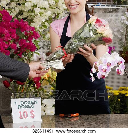 Customer giving cash payment to a female florist View Large Photo Image Stock Image - Customer giving cash payment to a female florist. Fotosearch