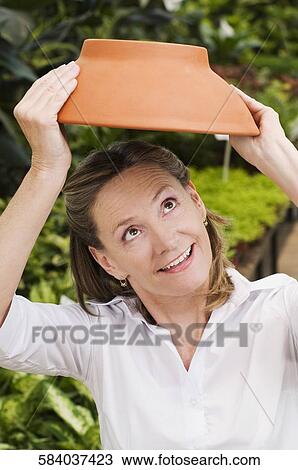 Customer holding earthenware pot in a greenhouse View Large Photo Image Stock Image - Customer holding earthenware pot in a greenhouse. Fotosearch