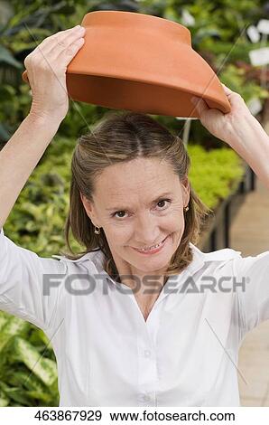 Customer holding earthenware pot in a greenhouse View Large Photo Image Stock Photo - Customer holding earthenware pot in a greenhouse. Fotosearch