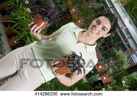 Stock Image - Customer holding potted plants. Fotosearch