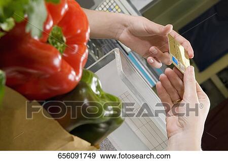 Customer making payment through credit card at the checkout counter View Large Photo Image Stock Photo - Customer making payment through credit card at the checkout counter. Fotosearch