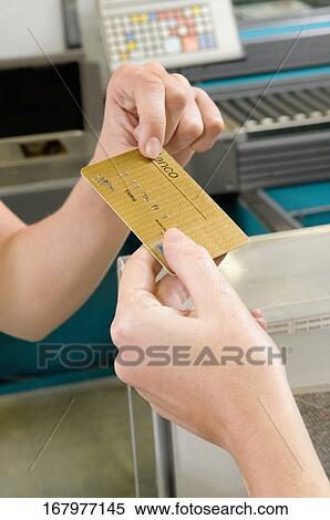 Customer making payment through credit card at the checkout counter View Large Photo Image Stock Photography - Customer making payment through credit card at the checkout counter. Fotosearch