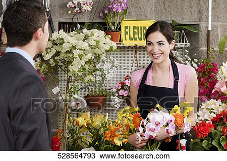 Stock Image - Customer purchasing a bouquet of flowers. Fotosearch