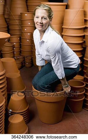 Stock Photograph - Customer sitting in a decorative urn and smiling. Fotosearch