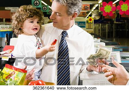 Customers making payments at the checkout counter View Large Photo Image Stock Image - Customers making payments at the checkout counter. Fotosearch