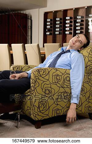 Drunk businessman sitting in an armchair View Large Photo Image Stock Photo - Drunk businessman sitting in an armchair. Fotosearch