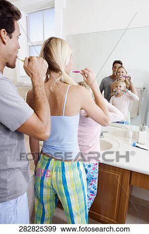 Family brushing teeth in the bathroom View Large Photo Image Stock Photo - Family brushing teeth in the bathroom. Fotosearch