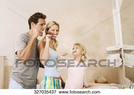 Family brushing teeth in the bathroom View Large Photo Image Stock Photo - Family brushing teeth in the bathroom. Fotosearch