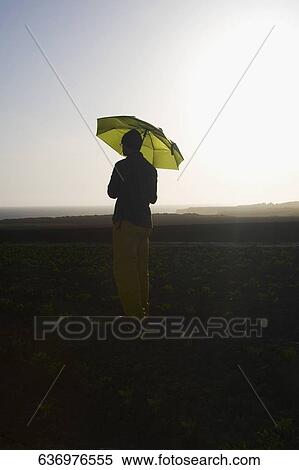 Farmer holding an umbrella in the field, California, USA View Large Photo Image Stock Photography - Farmer holding an umbrella in the field, California, USA. Fotosearch