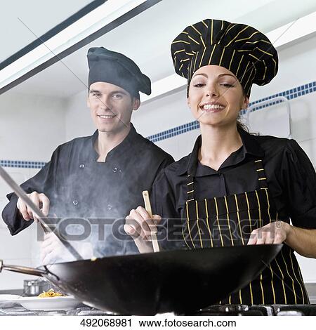 Female and a male chef cooking food in the kitchen View Large Photo Image Stock Image - Female and a male chef cooking food in the kitchen. Fotosearch