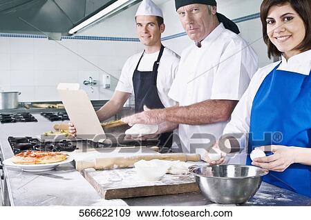 Stock Photo - Female and a male chef cooking food in the kitchen. Fotosearch