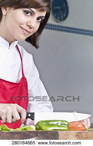 Female chef chopping bell pepper with a knife View Large Photo Image Stock Photography - Female chef chopping bell pepper with a knife. Fotosearch