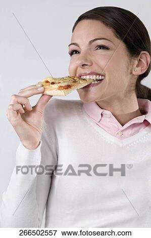 Stock Photo - Female chef eating a slice of pizza. Fotosearch
