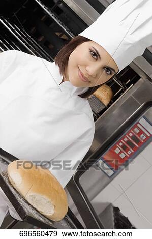 Female chef holding a bun in a tray View Large Photo Image Stock Photo - Female chef holding a bun in a tray. Fotosearch