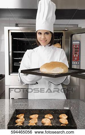 Female chef holding a bun in a tray View Large Photo Image Stock Photograph - Female chef holding a bun in a tray. Fotosearch