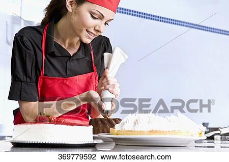 Female chef icing a cake View Large Photo Image Stock Image - Female chef icing a cake. Fotosearch