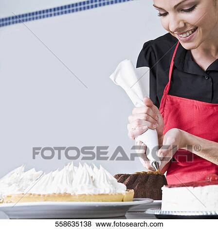 Female chef icing a cake View Large Photo Image Stock Photo - Female chef icing a cake. Fotosearch