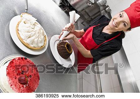 Female chef icing a cake View Large Photo Image Stock Photography - Female chef icing a cake. Fotosearch
