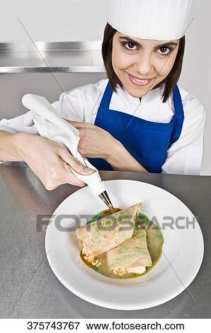 Female chef icing pastries and smiling View Large Photo Image Stock Photo - Female chef icing pastries and smiling. Fotosearch