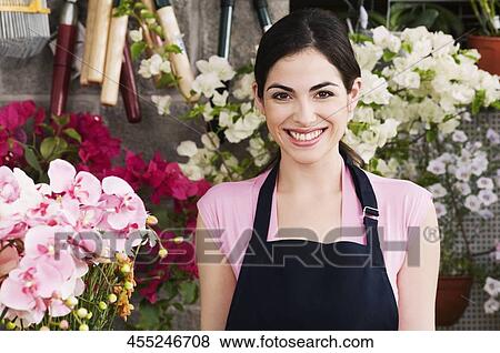 Stock Photo - Female florist smiling in a flower shop. Fotosearch