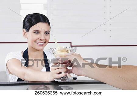 Female ice cream seller giving ice cream to a customer View Large Photo Image Stock Photography - Female ice cream seller giving ice cream to a customer. Fotosearch