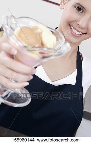 Female ice cream seller holding a glass of ice cream View Large Photo Image Picture - Female ice cream seller holding a glass of ice cream. Fotosearch