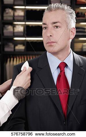 Stock Photograph - Female tailor taking measurement of a businessman. Fotosearch