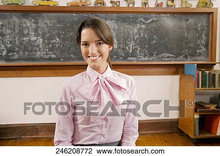 Female teacher smiling in a classroom View Large Photo Image Stock Image - Female teacher smiling in a classroom. Fotosearch