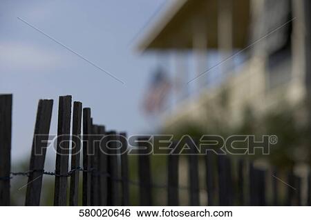 Fence with a building in the background View Large Photo Image Stock Photograph - Fence with a building in the background. Fotosearch