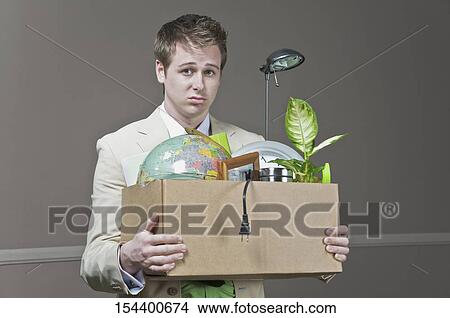 Fired businessman holding his office belongings View Large Photo Image Picture - Fired businessman holding his office belongings. Fotosearch